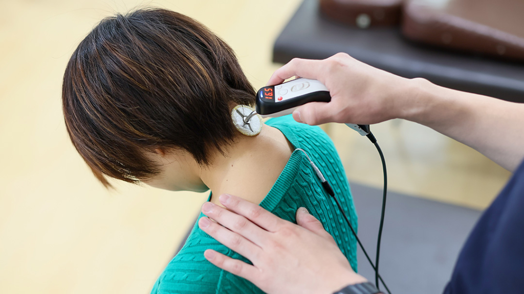肩こりで電気治療する女性